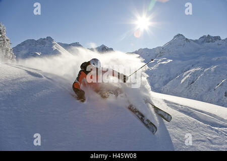 Austria Vorarlberg, Silvretta Nova, uomo giovane, freeride, sci area, zona freeride e deep-coperta di neve, coperta di neve e neve e neve profonda, polvere di neve, sci, trend, il sole, Sunray, persone, sciatori, uomo giovane, casco da sci, protezione, motion, turismo, sport, sport invernali, hobby, paesaggio invernale, montagne delle Alpi, meteo, chiaramente, Foto Stock