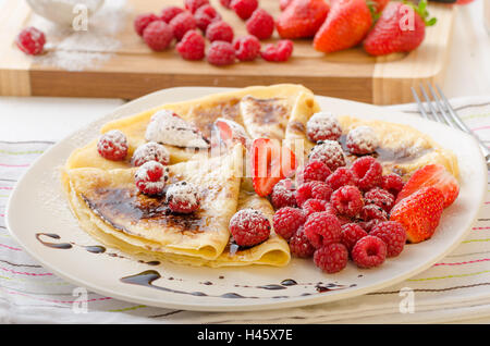 Frittelle fatte in casa con riduzione di balsamico e frutta fresca, fragole e lamponi Foto Stock
