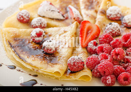 Frittelle fatte in casa con riduzione di balsamico e frutta fresca, fragole e lamponi Foto Stock