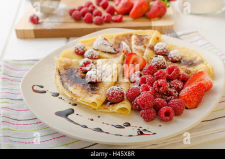 Frittelle fatte in casa con riduzione di balsamico e frutta fresca, fragole e lamponi Foto Stock