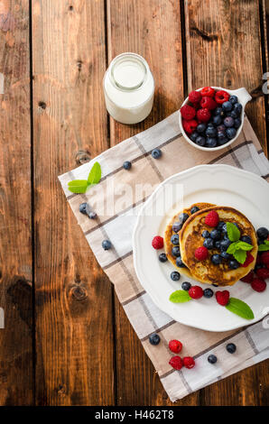 Frittelle con frutti di bosco e menta fresca frutta e latte Foto Stock