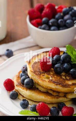 Frittelle con frutti di bosco e menta fresca frutta e latte Foto Stock