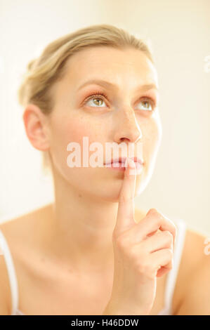 Giovane donna con il dito in bocca, Foto Stock