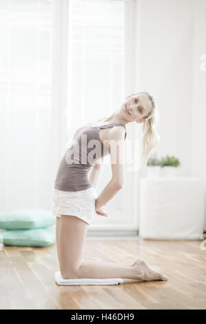 Giovane donna fa di una pratica di ginnastica, Foto Stock