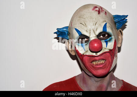 Primo piano di una paura male clown contro un sfondo bianco Foto Stock