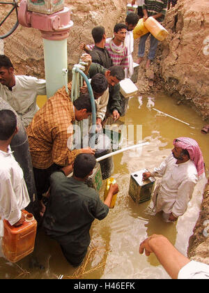 15 Aprile 2003 appena a sud di Ur, nei pressi di Tallil, iracheni locali di utilizzare tubi flessibili di toccare una pipeline e riempire i contenitori in plastica con benzina. Foto Stock