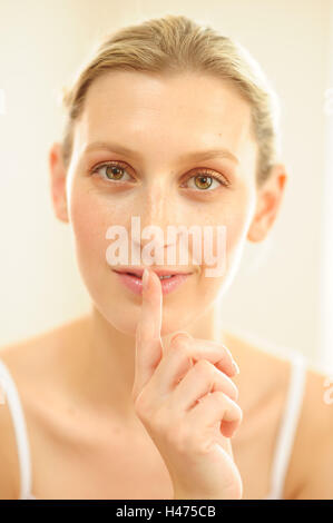 Giovane donna con il dito in bocca, Foto Stock