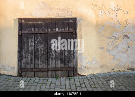 Vecchie porte in legno graffiato parete gialla Foto Stock