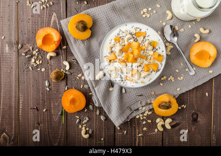 Albicocche domestico musli yogurt con il latte e croccante di dadi e sementi sane chia Foto Stock