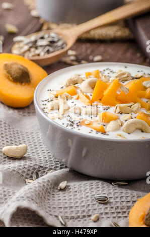 Albicocche domestico musli yogurt con il latte e croccante di dadi e sementi sane chia Foto Stock