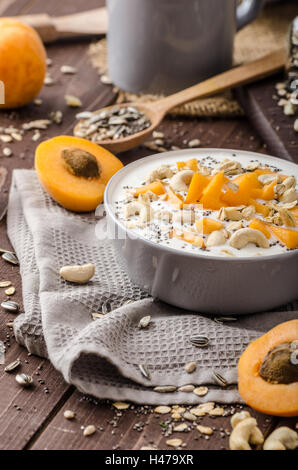 Albicocche domestico musli yogurt con il latte e croccante di dadi e sementi sane chia Foto Stock