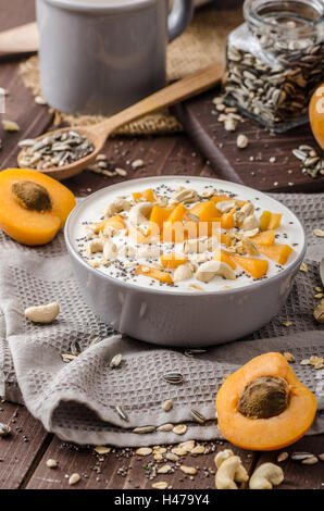 Albicocche domestico musli yogurt con il latte e croccante di dadi e sementi sane chia Foto Stock
