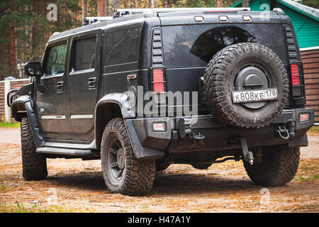 San Pietroburgo, Russia - 9 Ottobre 2016: Nero Hummer H2 veicolo sorge su sporco country road, closeup vista posteriore Foto Stock