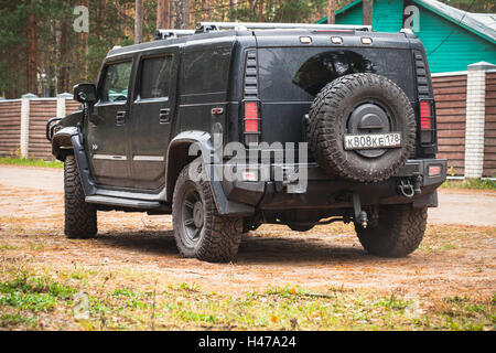 San Pietroburgo, Russia - 9 Ottobre; 2016: Nero Hummer H2 veicolo sorge su sporco country road; vista posteriore Foto Stock