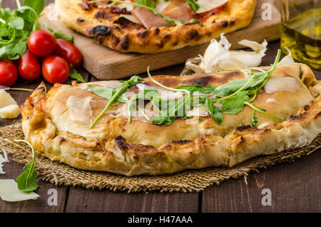 Calzone pizza, riempito di erbe, formaggio e pomodori Foto Stock