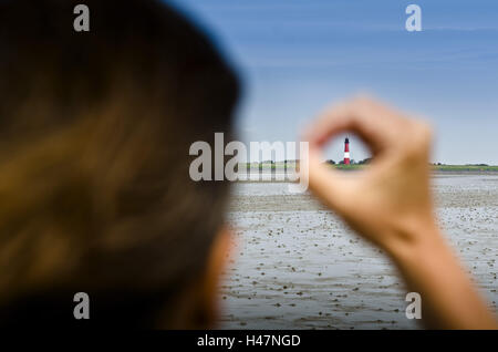 Germania, Schleswig-Holstein, Pellworm, velme, il Wadden Sea, faro, donna, mano, dito, visualizzazione Foto Stock