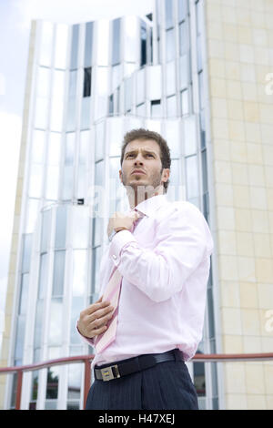 Edifici, uomo, giovani, tie raddrizzare, seriamente, metà ritratto, alto, edificio di uffici, edificio aziendale, business, persona, imprenditore, gesto, barba di tre giorni, barba lunga, dapperly, elegantemente, smart, con orgoglio, auto-fiduciosi, con successo, orientati al successo, lungimiranza e determinazione, con lungimiranza, esterno, Foto Stock