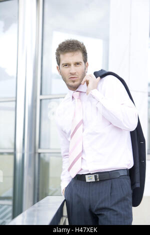 Edifici, uomo, giovani, seriamente, metà ritratto, business, persona, stand, andare, suit giacca sportiva spalla, imprenditore, barba di tre giorni, barba lunga, dapperly, elegantemente, intelligente e pensosa, self-fiduciosamente, risolutamente, orientati al successo, Foto Stock