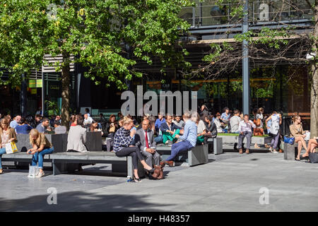 Gli impiegati godendo il tempo soleggiato a New Street Square a Londra England Regno Unito Regno Unito Foto Stock