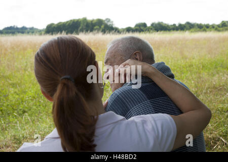 Senior uomo si siede con sua figlia su un banco, Foto Stock