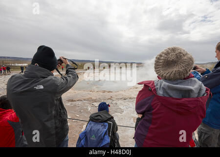 I turisti stanno intorno in attesa per la strokkur geyser a scatenarsi geysir Islanda Foto Stock