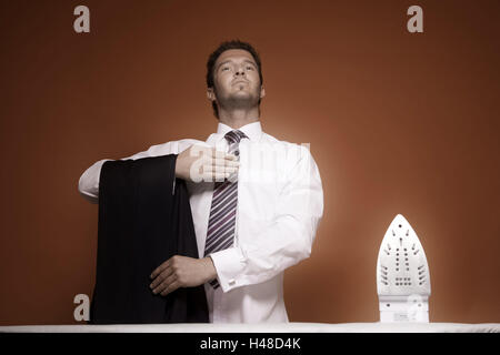 L'uomo, pantaloni attesa, metà ritratto, uomo, 30-40 anni, imprenditore, maglietta, la cravatta, business, persona, giovane, single dapperly, con orgoglio, seriamente, stand, presente, ferro, club insieme, self-fiduciosi, indipendentemente, indipendentemente, singolo, domestico, i lavori domestici, ferro e asse da stiro, all'interno, studio Foto Stock
