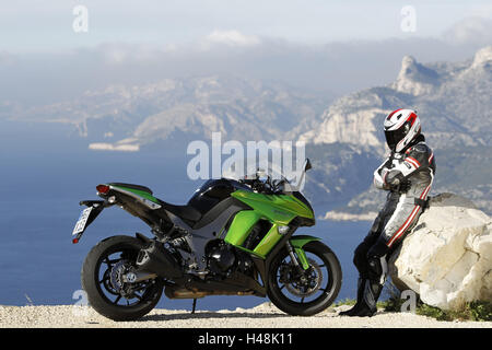 Motociclo, Kawasaki Z 1000 SX, sports bike, strada costiera, conducente in piedi oltre, paesaggio mediterraneo in background, Foto Stock