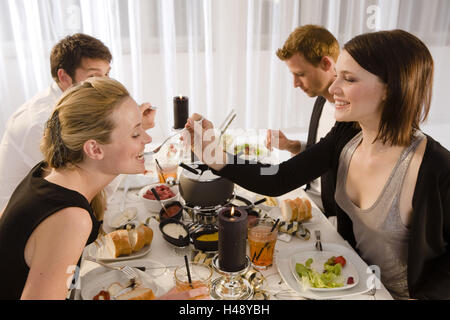 Festa di Capodanno, fonduta, coppie, giovani, felice, tabella, sedersi, Foto Stock