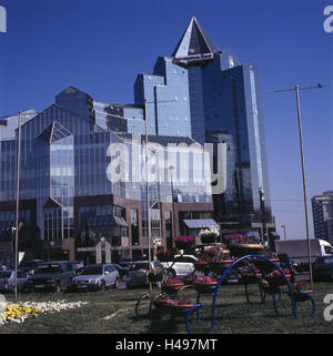 Il Kazakistan, Almaty, banca, fuori, edificio, facciata, vetro anteriore, cielo blu, finanze, parcheggio, veicoli, fiori, Foto Stock