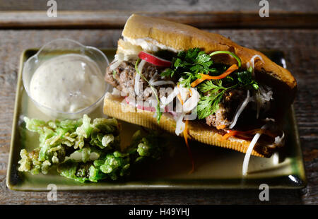 Un cibo di strada "sandwhich Banh Mi' con una polpetta di Berlino, ravanelli, cavolo rapa dolce-amaro e salsiccia di fegato lungo con la foresta di Sprea bastoncini di cetriolo in una copertura croccante fatto di verde di riso e una mostarda-chili di maionese giace su di una piastra al ristorante Vietnamita Anjoy in Rykestrasse nel quartiere di Prenzlauer Berg di Berlino, Germania, 13 ottobre 2016. Esso offre classici della cucina di Berlino nella loro versione vietnamita come combinazione di due culture alimentari in una settimana di azione sotto il motto "polpette di Berlino in un viaggio attraverso il Vietnam'. Il menu è stato creato da chef internet Henriette Wulff aka H Foto Stock