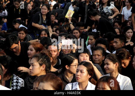 Bangkok, Tailandia. 14 ott 2016. Una donna visualizzare i ritratti della Thailandia del Re Bhumibol Adulyadej su Thai baht note come shewait sul ciglio della strada mentre il suo corpo è stato spostato al Grand Palace di Bangkok. Thailandia del Re Bhumibol Adulyadej è deceduto dopo una lunga malattia, il palazzo ha annunciato il 13 ottobre 2016 Credit: Piti un Sahakorn/Alamy Live News Foto Stock