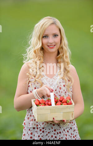 Giovane donna su un campo di fragole, Foto Stock