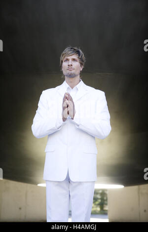 L'uomo, stand Young, seriamente, barba, tuta, pregare, luce posteriore, persona, biondo scuro, maglietta, bianco, espressione, soddisfazione, concezione, celeste, celeste, manifestazione, Angelo, illuminismo Foto Stock