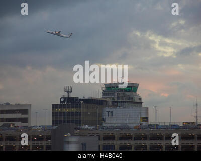 Un aereo decolla dal Terminal 1 dell'Aeroporto Internazionale di Manchester prese su una torbida serata d'autunno. Foto Stock