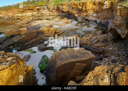 Sunrise oltre la costa di roccia in Atlantico a Luz, a ovest di Lagos, Algarve, Portogallo, Europa Foto Stock