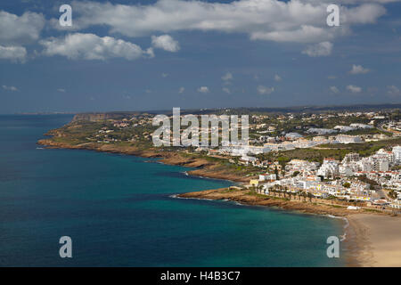 Costa di roccia presso l'Atlantico e il piccolo villaggio di Luz, a ovest di Lagos, Algarve, Portogallo, Europa Foto Stock