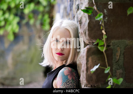 Giovane donna bionda, tatuato Foto Stock