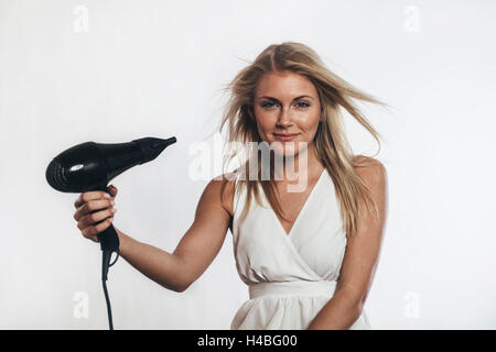 Donna asciugare i capelli Foto Stock