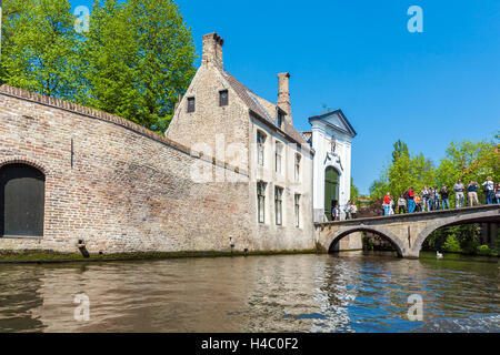 BRUGES, Belgio - Aprile 6, 2008: turisti salutare un tour in barca dal ponte di fronte al beghinaggio Foto Stock
