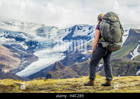 Un giovane escursionista che si affaccia su un ghiacciaio in Thorsmörk Foto Stock