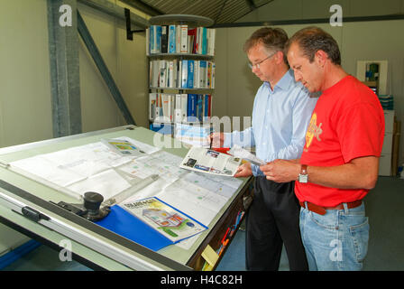 Bellinzona, Svizzera - 3 Giugno 2005: gli ingegneri che lavorano insieme alla tavola da disegno su di loro office Foto Stock