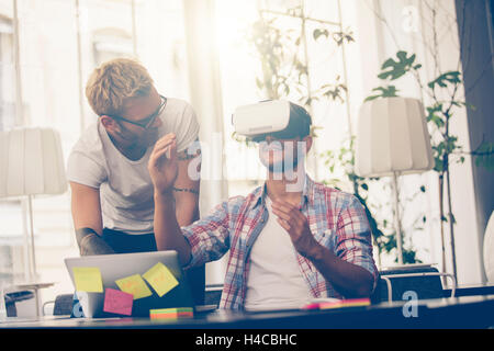 Gli imprenditori test di realtà virtuale tecnologia con un collega in ufficio. Foto Stock