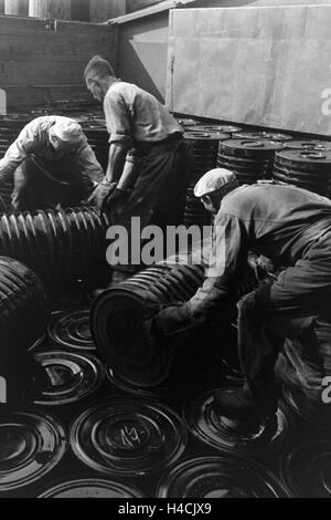 Lagerarbeiter der Rhenania Ossag Mineralölwerke AG DI AMBURGO das verladen Bitumenprodukt Mexphalt auf Schiffe, Deutschland 1930er Jahre. Warehousemen della Rhenania Ossag Mineraloelwerke AG ad Amburgo il carico di una nave con il bitume prodotto Mexphalt, Ge Foto Stock