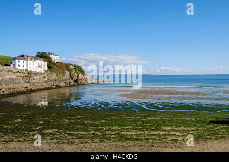 Case costruite sulle rocce e pareti rocciose a picco sul mare a Portmellon, Cornwall, Regno Unito Foto Stock