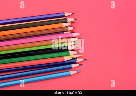 Set di matite colorate su sfondo rosa. Foto Stock