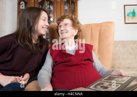 Il 95-anno-vecchia nonna guarda album di foto con il suo 14-anno-vecchio nipote, Foto Stock