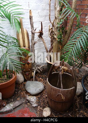 An assortment of unusual and tribal artifacts arranged against a wall Foto Stock