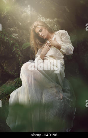 Graceful donna in posa nella foresta da sogno. Etereo e fantasia Foto Stock
