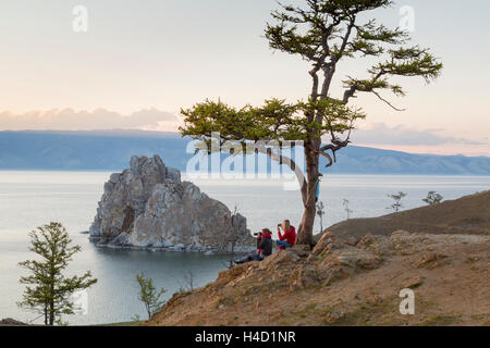 I turisti osservare la costa del lago Baikal, lo sciamano rock, la struttura ad albero dei desideri e cape Burhan sull'isola di Olkhon in Russia Foto Stock