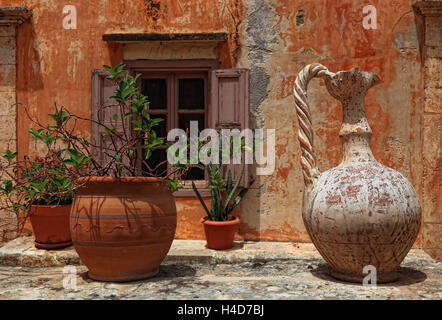 Creta, penisola di Akrotiri, Moni Agada Triada, il chiostro della Santissima Trinità, nel cortile interno del chiostro pianta, finestra, vasi da fiori e vecchia brocca di tono Foto Stock